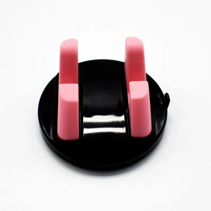 Black round desktop phone holder with two pink adjustable stands on white background