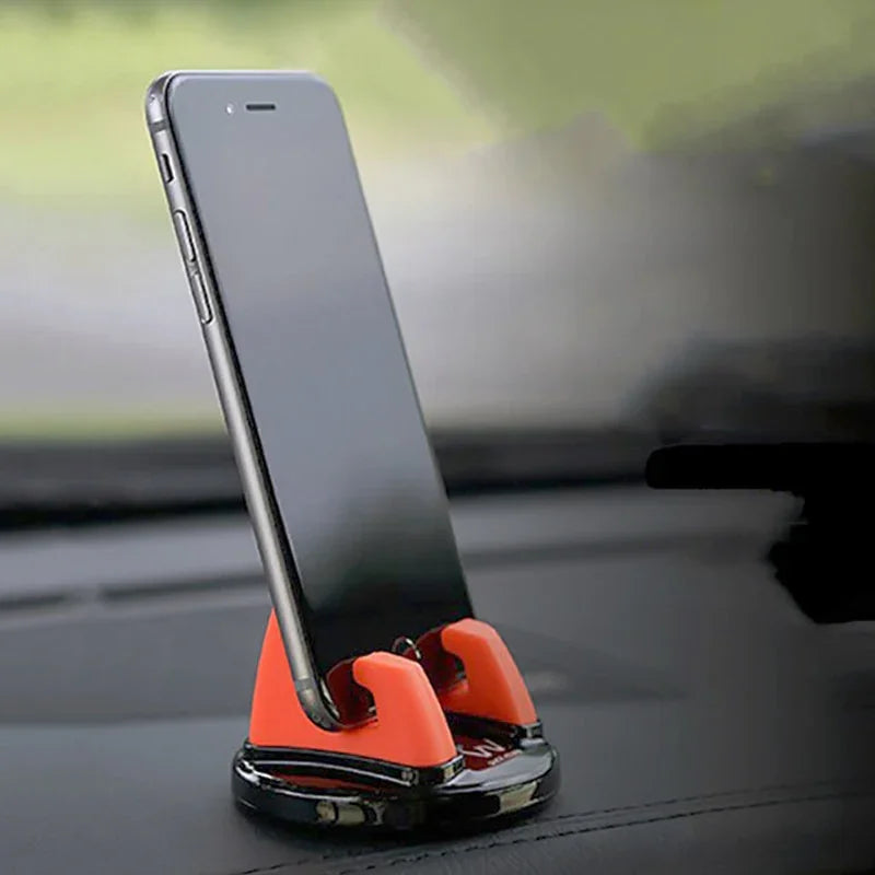 Smartphone in orange and black car dashboard phone holder, hands-free mount