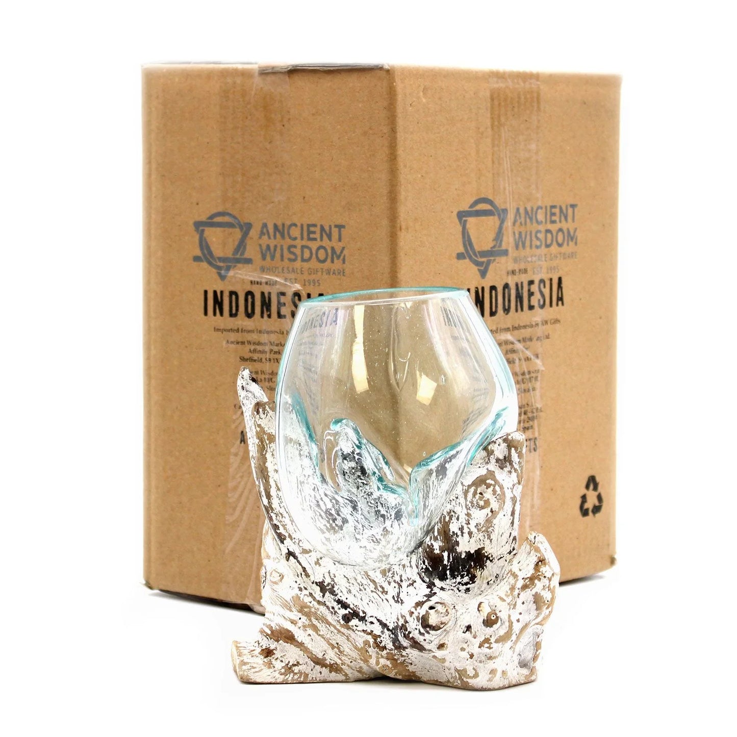 Handcrafted glass bowl on driftwood base in front of cardboard packaging, home decor accessory.
