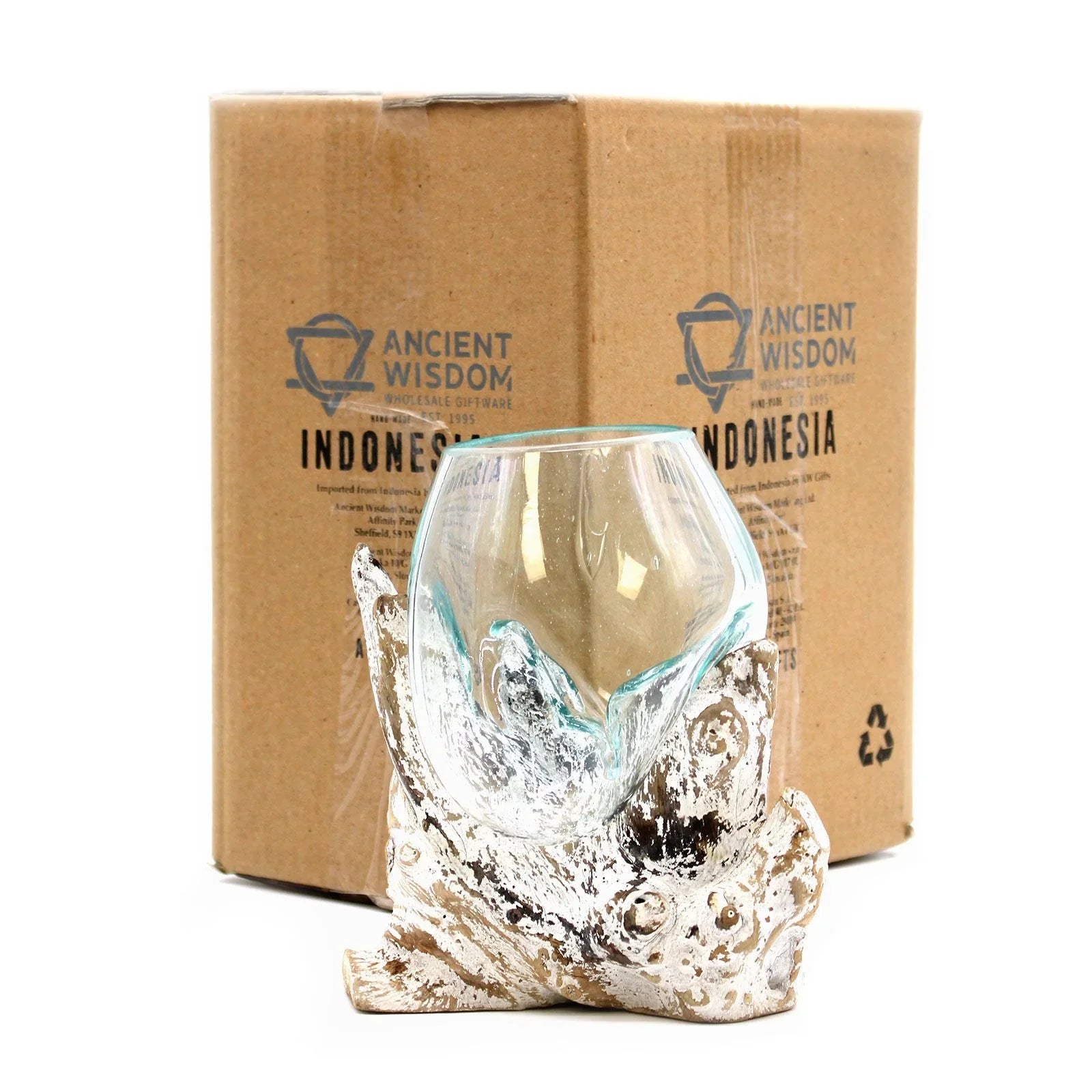 Handcrafted glass bowl on driftwood base in front of cardboard packaging, home decor accessory.